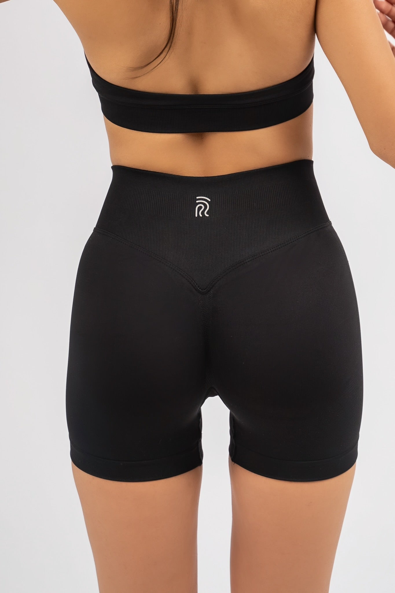 טייץ קצר מחטב EMBER של YARA בצבע שחור על דוגמנית – בד נושם, גזרה גבוהה ונוחה לאימון.