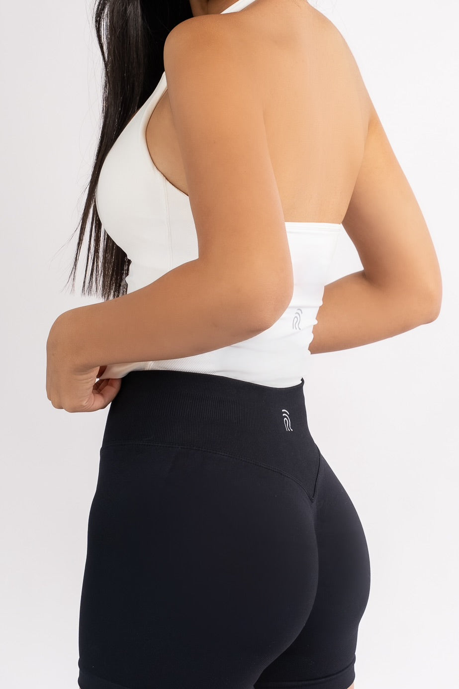 דוגמנית לובשת גופיית ספורט מחטבת בצבע לבן דגם EMBER של YARA